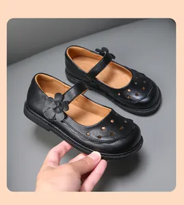 Detailansicht der schwarzen Mädchen-Lederschuhe mit Blumenakzent und Sternen