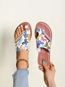 Detailansicht Damen-Zehentrenner mit bunten Schmetterlingsmustern und Glitzerriemen.