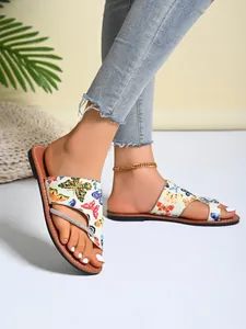 Detailansicht römischer Zehensteg-Sandalen mit buntem Schmetterlingsdruck und Strass