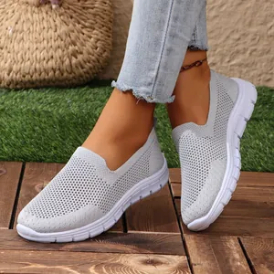 Sneaker slip-on casual in maglia traspirante grigia da donna mostrate in un ambiente all'aperto