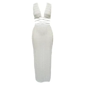 Detailed view of white textured lace two-piece set featuring halter top and maxi skirt.