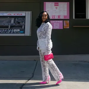 Elegante conjunto de encaje blanco transparente con camisa de manga larga y pantalón a juego.