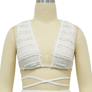Detailed view of white ruffled lace crop top featuring deep V-neck and tie-up waist bands