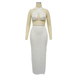 Detailed view of white lace halter top and maxi skirt set on dress form