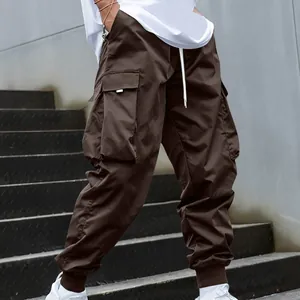 Detail view of men's brown multi-pocket cargo pants with tapered elastic cuffs