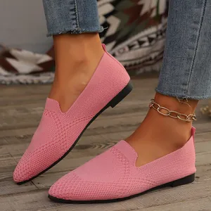 Detailansicht der rosafarbenen Fly-Knit-Slipper mit spitzer Kappe für Damen auf Holz.