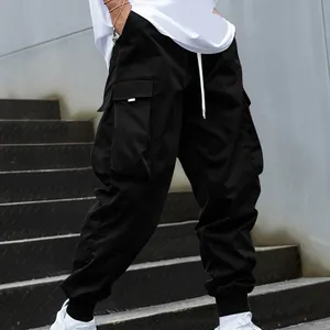Close-up detail of black multi-pocket cargo pants featuring tapered elastic jogger cuffs