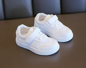 Detalle de los zapatos casuales blancos para niños con cómodos cierres de velcro