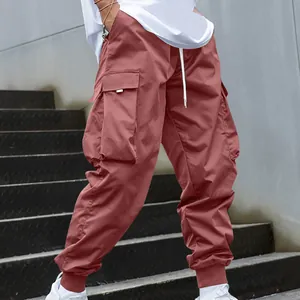 Close-up of men's loose cargo pants with multi-pockets and jogger cuffs in terracotta