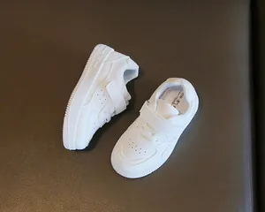 Primer plano de zapatillas blancas para niños con velcro y detalles perforados