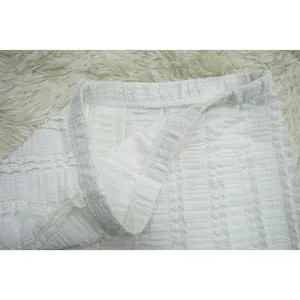 Close-up of white lace fabric texture and waistband on women's skirt set