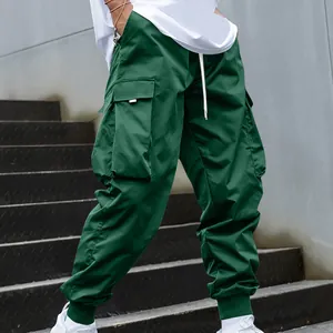 Close-up of green cargo pants featuring multiple utility pockets and elastic cuffs