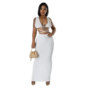 Detailed view of white lace textured two-piece set featuring sleeveless crop top and maxi skirt