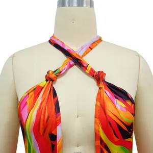 Detailed view of the vibrant abstract print and knot straps on this halter jumpsuit