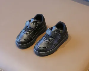 Detalle de zapatillas negras transpirabili para niños con correa de velcro ajustable
