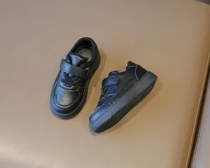 Detalle de zapatos casuales negros para niños con cierre de velcro y piel sintética