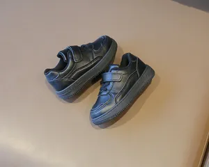 Primer plano de zapatillas casuales negras para niños con tiras de velcro para el colegio