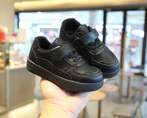 Detalle de cerca de zapatillas casual negras para niños con tiras de velcro ajustables