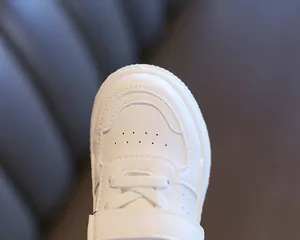 Macro de zapatillas blancas para niños con perforaciones transpirables y velcro