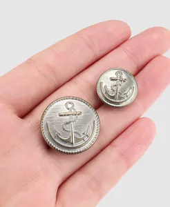 Gros plan de boutons d'ancre en laiton argenté vintage avec des détails nautiques