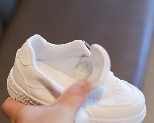 Vista detallada del forro transpirable y el cierre de velcro en las zapatillas blancas infantiles