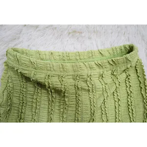 Close-up macro detail of green pleated lace fabric texture on women's dress waistband