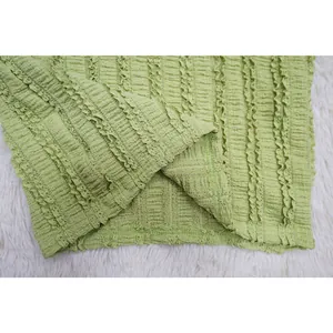 Close-up of the light green tripe-textured lace fabric on a women's dress set