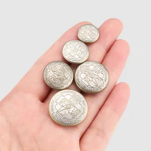 Five vintage brass buttons with ornate crown crest engraving on neutral background