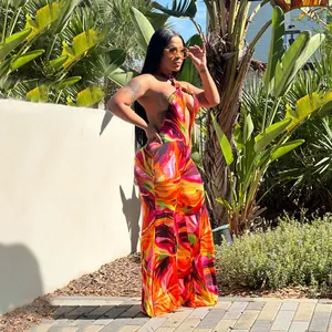 Vibrant abstract print halter backless wide-leg jumpsuit shown in outdoor setting