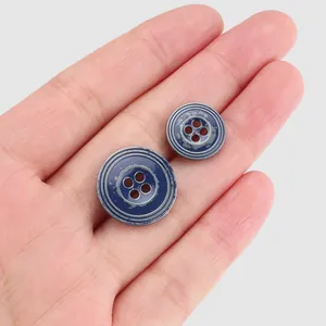 Set of vintage blue four-hole metal buttons with circular engraved patterns for clothing.