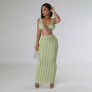 Detailed view of light green two-piece set with textured crop top and high-waist maxi skirt