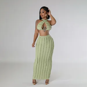 Detailed texture of green pleated sleeveless crop top and long skirt set on model