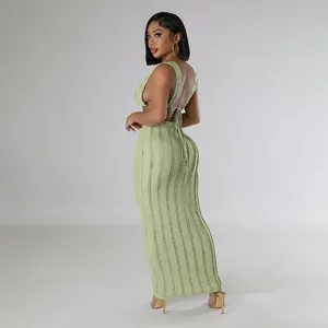 Side profile view of sage green textured backless top and matching long maxi skirt