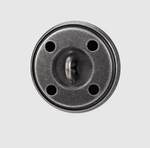 Close-up of a vintage grey metal button featuring four holes and a central sewing shank.