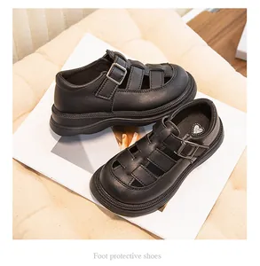 Primo piano di sandali romani in pelle nera per bambini con design intrecciato traspirante