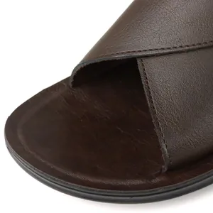 Close-up detail of brown leather cross-strap on men's summer Roman sandals