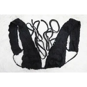 Detailed view of black ruffled lace sleeveless top with multi-strap tie-back design.