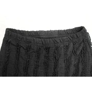 Detailed macro view of black textured ruffled fabric with delicate lace trim edges