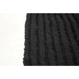 Close-up detail of black tripe-textured lace fabric for elegant women's dress set