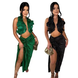 Dettaglio completo donna: top senza maniche con volant e gonna a pieghe con spacco verde e nero