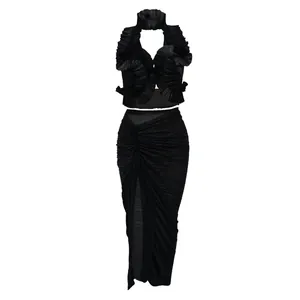 Dettaglio del set nero a due pezzi con top a balze e gonna a pieghe con spacco laterale