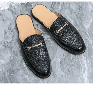 Close-up view of black glitter men's mules loafers featuring a gold metal bit detail