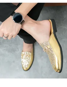 Detailed view of men's gold glitter loafers with stylish metal buckle and mule design.