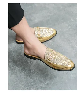 Close-up detail of stylish men's gold glitter half-slippers with metallic buckle
