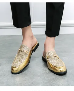 Detailed macro view of men's trendy gold glitter loafers featuring a metal buckle