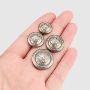 Vintage metal buttons with embossed heraldic lion crown motif on palm