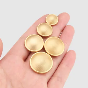 Ensemble de boutons en laiton doré mat de différentes tailles avec une texture rayée fine