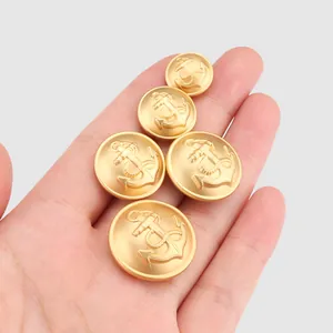 Set aus matten goldfarbenen Messingknöpfen mit klassischem geprägtem Schiffsankermotiv.