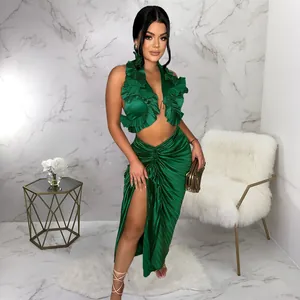 Elegante set verde con top all'americana a balze e gonna a pieghe con spacco