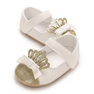 Nahaufnahme weißer Lauflernschuhe für Mädchen mit goldener Glitzerspitze und Krone